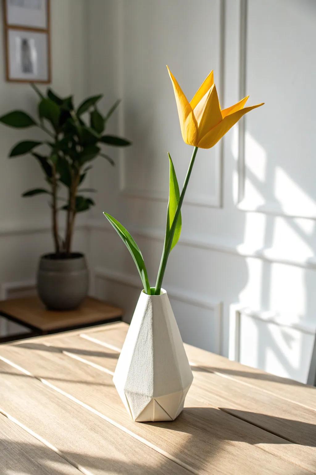 Embrace simplicity and charm with a bright origami tulip in a handmade vase, perfect for adding a touch of elegance to any space.