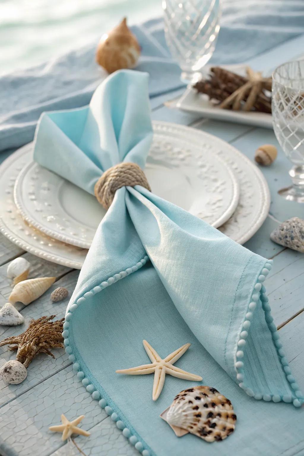 A silk napkin folded into a fish tail, perfect for adding a nautical vibe to your table setting.
