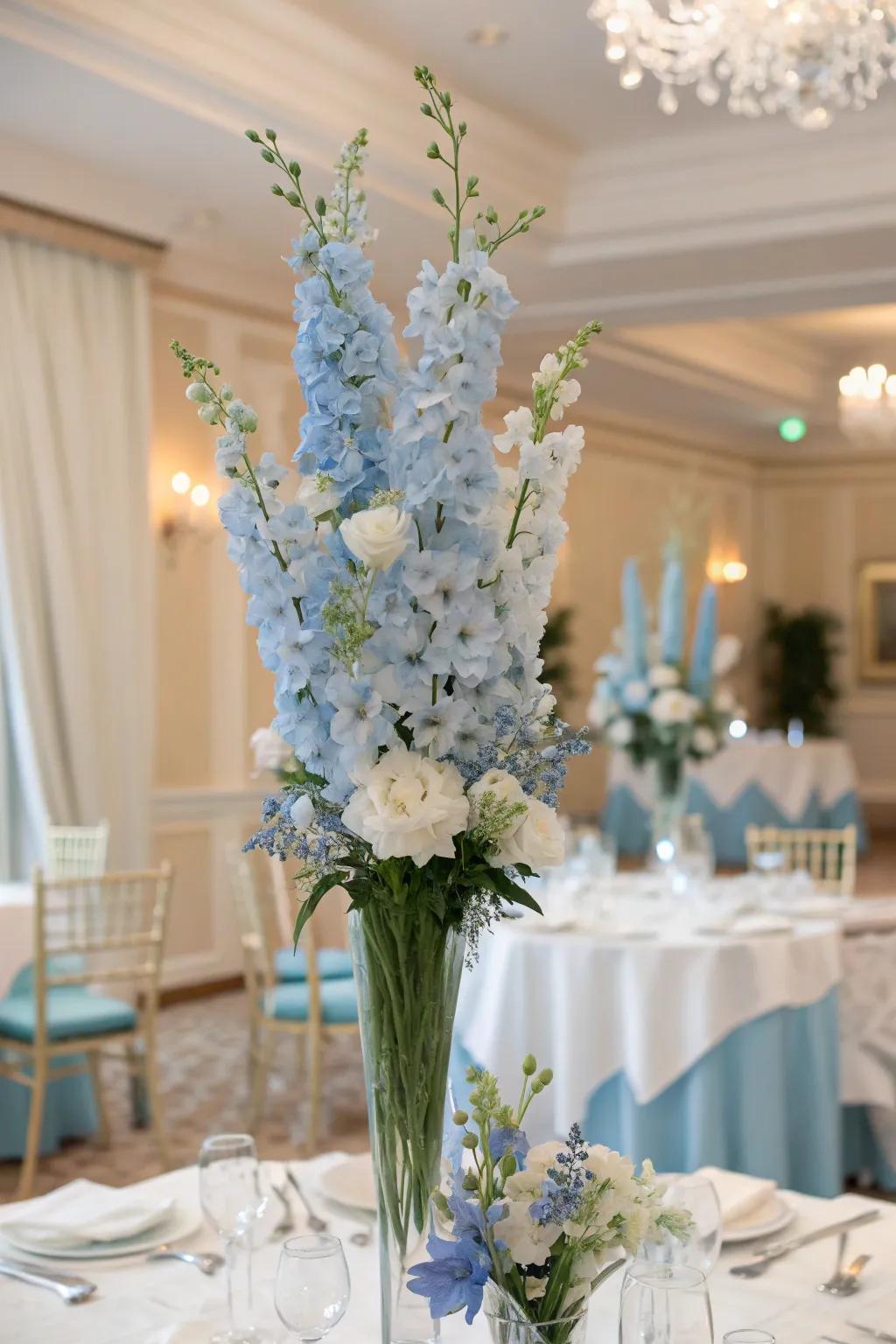 Tall centerpieces of light blue delphiniums creating an elegant atmosphere.