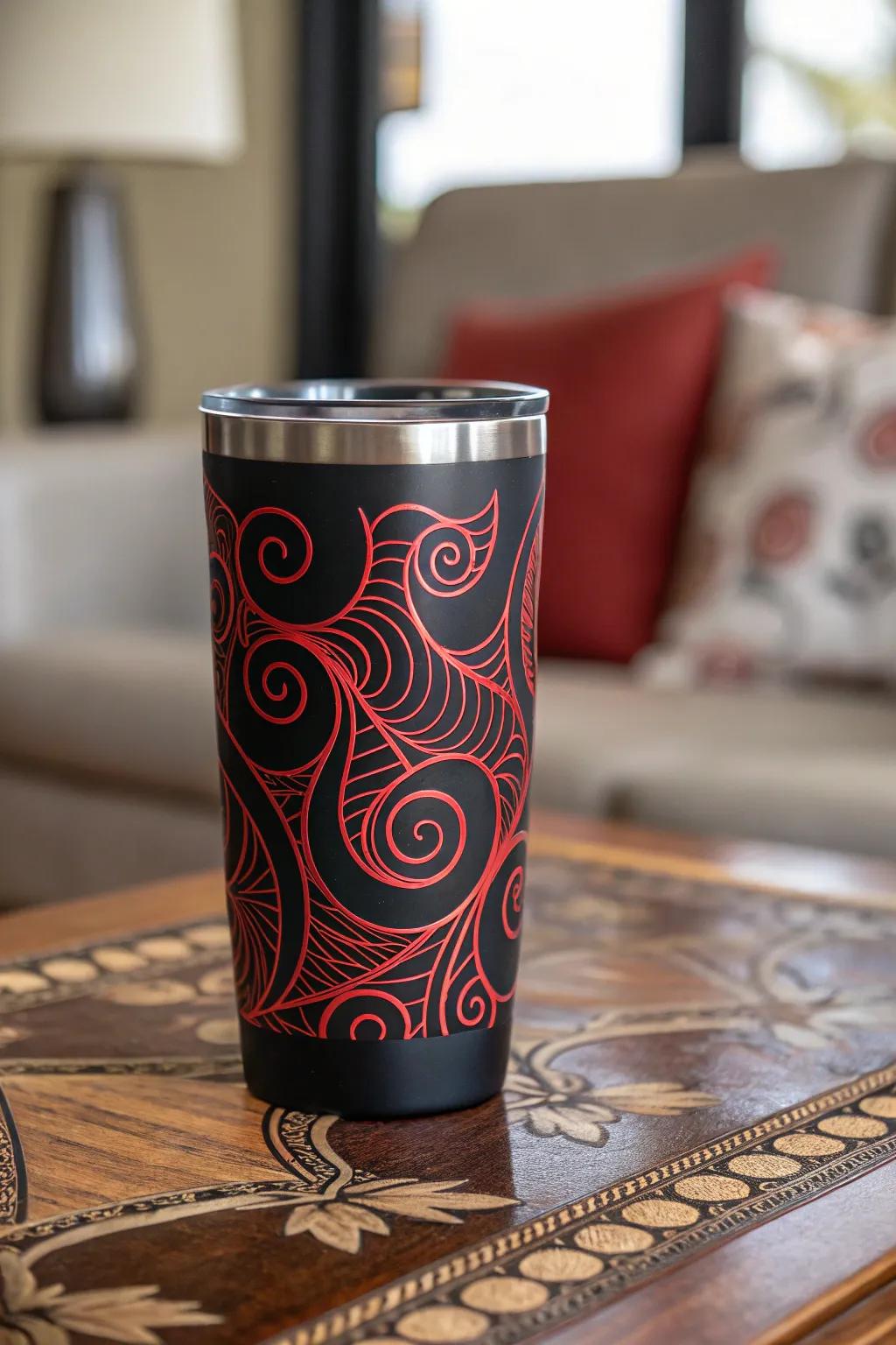 Abstract red swirls on a black tumbler create a playful look.