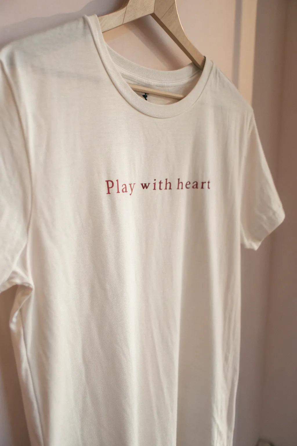 Embrace simplicity and positivity with our 'Play with Heart' shirt—crafted for those who value style and inspiration.