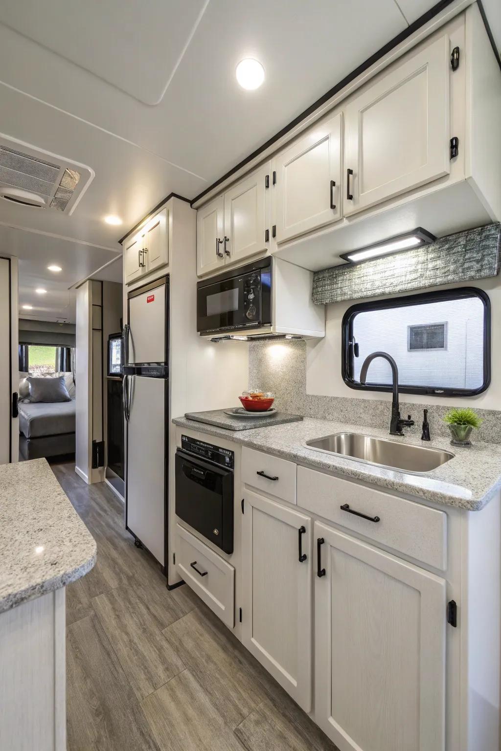 A modern travel trailer kitchen featuring sleek cabinetry and compact appliances for efficient meal prep.