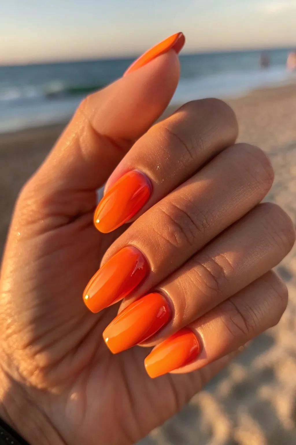 Embrace the essence of summer with these stunning sunset orange nails, perfect for any beach outing.